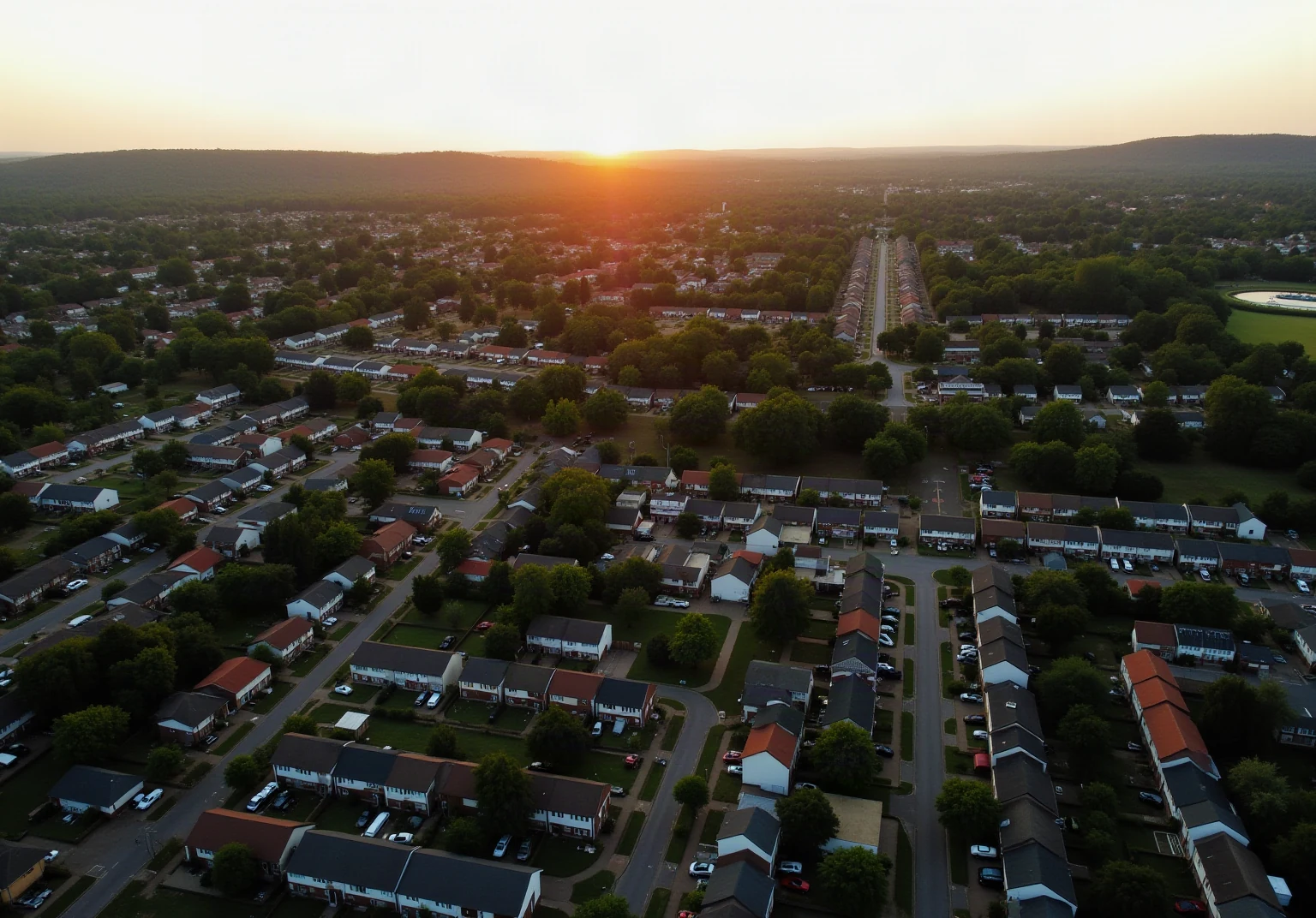Aerial view of a leafy Greater Cincinnati suburban neighborhood with varied rooftops at golden hour, rolling hills, photographic, no text